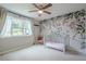 Charming bedroom with a floral accent wall, large window, and a classic crib at 1137 Poplar Log Pl, Austell, GA 30168
