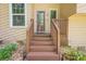 Inviting front porch with wooden stairs, decorative rock landscaping, and glass front door at 1137 Poplar Log Pl, Austell, GA 30168