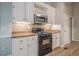 Updated kitchen features white cabinets, stainless steel appliances, and granite countertops at 1137 Poplar Log Pl, Austell, GA 30168