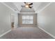 Spacious primary bedroom with tray ceiling, carpet, and large window at 12 Isabella Ne Ct, Cartersville, GA 30121