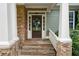 Elegant front entrance with a stone porch, decorative wreath, and white columns offers a warm welcome at 12 Isabella Ne Ct, Cartersville, GA 30121