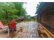 A wet wooden back deck featuring wood railings and outdoor chairs offering beautiful views of the backyard at 218 Green Acre Ln, Cartersville, GA 30121