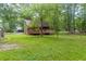 Exterior shot of a cozy log cabin with a spacious wooden deck and surrounded by lush greenery at 218 Green Acre Ln, Cartersville, GA 30121