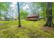 Exterior view of a wooded cabin with a beautiful backyard, trees and spacious wooden deck at 218 Green Acre Ln, Cartersville, GA 30121