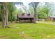 Log cabin featuring dormer windows and inviting front porch surrounded by a green lawn and trees at 218 Green Acre Ln, Cartersville, GA 30121