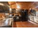 Modern kitchen with black cabinets, granite countertops, and stainless steel appliances in a cozy space at 218 Green Acre Ln, Cartersville, GA 30121