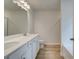Bright bathroom featuring a double vanity with white cabinets, quartz countertop, and wood-look flooring at 389 Navigator Ln, Mcdonough, GA 30253