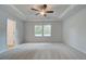 Spacious main bedroom with carpet, tray ceiling, ceiling fan, and two windows at 389 Navigator Ln, Mcdonough, GA 30253
