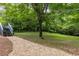 Green backyard with stairs to deck and gravel walking path through the trees at 1060 Pinedale Se Dr, Smyrna, GA 30080