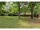 Well-maintained backyard with a lush lawn, mature trees, and a fenced perimeter at 1060 Pinedale Se Dr, Smyrna, GA 30080