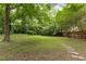 Large backyard featuring a lush green lawn and mature trees at 1060 Pinedale Se Dr, Smyrna, GA 30080