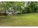 Expansive backyard with a lush lawn, mature trees, and the home in the background at 1060 Pinedale Se Dr, Smyrna, GA 30080