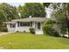 Charming home with manicured lawn, white painted brick, and blue shutters at 1060 Pinedale Se Dr, Smyrna, GA 30080