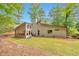 A private backyard has a sunroom, lots of grass, and is surrounded by mature trees offering shade and beauty at 2000 Kristian Way, Roswell, GA 30076