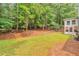 A large backyard is mostly grass and surrounded by lots of beautiful, mature trees adding privacy and shade at 2000 Kristian Way, Roswell, GA 30076