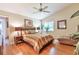 Primary bedroom with wood floors, ceiling fan, a large window, and comfortable furnishings at 2000 Kristian Way, Roswell, GA 30076