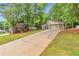 Suburban home with an extra long driveway, a two-car garage and lots of beautiful trees in the front yard at 2000 Kristian Way, Roswell, GA 30076