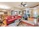 Inviting living room with a red sofa, glass table, ceiling fan, and an open view to the kitchen at 2000 Kristian Way, Roswell, GA 30076