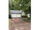 Exterior view featuring a two-car garage, driveway, and greenery around the house at 425 Rockingham Ln, Woodstock, GA 30189