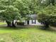 Quaint one-story home with green lawn and mature trees offering shade and privacy at 425 Rockingham Ln, Woodstock, GA 30189