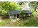 Overgrown yard featuring a cinder block outbuilding, showcasing the potential for creative transformation at 1395 Clay Sw Rd, Mableton, GA 30126
