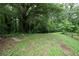 Expansive backyard featuring mature trees and green grass, perfect for outdoor activities at 1395 Clay Sw Rd, Mableton, GA 30126