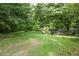 Large, private backyard with mature trees and partial fencing, ideal for recreation at 1395 Clay Sw Rd, Mableton, GA 30126