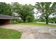 Wide view of the front exterior of the home with a large driveway and mature trees at 1395 Clay Sw Rd, Mableton, GA 30126