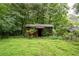 Quaint, rustic outbuilding amidst a verdant backdrop, perfect for storage or a unique hobby space at 1395 Clay Sw Rd, Mableton, GA 30126