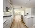 Bright kitchen features white cabinetry, stainless appliances, marble counters, tiled backsplash, and wood-look flooring at 2856 Knob Creek Dr, Snellville, GA 30078