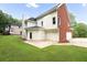 Well-maintained home features an expansive backyard with lush green grass and mature trees at 3932 E Saddle Ridge Dr, Lithonia, GA 30038