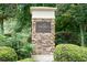 Elegant community sign with stone detail, surrounded by lush landscaping and manicured shrubs at 3932 E Saddle Ridge Dr, Lithonia, GA 30038