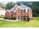 Charming two-story red brick home featuring black shutters and a well-manicured front lawn at 3932 E Saddle Ridge Dr, Lithonia, GA 30038