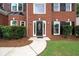 Brick front exterior with black door, manicured shrubs, and green lawn at 3932 E Saddle Ridge Dr, Lithonia, GA 30038