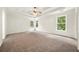 Spacious main bedroom with plush carpet, tray ceiling, fan, and natural light at 3932 E Saddle Ridge Dr, Lithonia, GA 30038
