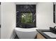 Bathroom featuring a freestanding tub with a black marble accent wall and double sink vanity at 178 Wesley Ne Ave # A, Atlanta, GA 30307