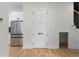 Bright hallway with hardwood floors, leading to a modern kitchen with stainless steel appliances and sleek white cabinets at 178 Wesley Ne Ave # A, Atlanta, GA 30307