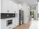 Modern kitchen with white cabinets, black hardware, stainless appliances and black tiled backsplash at 178 Wesley Ne Ave # A, Atlanta, GA 30307