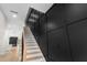 Elegant staircase featuring a striking black accent wall and hardwood steps at 178 Wesley Ne Ave # A, Atlanta, GA 30307