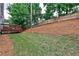 Backyard featuring a wood deck, wood fence, a sloped yard, grass and pine straw at 2956 Silver Hill Se Ter, Atlanta, GA 30316