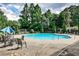 Community pool with lounge chairs, tables, umbrellas, and mature landscaping for a relaxing experience at 2956 Silver Hill Se Ter, Atlanta, GA 30316