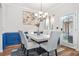 Dining room with modern chandelier, marble table, and blue wainscoting at 3143 Bonnes Dr, Stonecrest, GA 30038