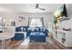 Bright living room featuring a blue sectional, ceiling fan, and decorative shelving at 3143 Bonnes Dr, Stonecrest, GA 30038