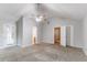 Spacious bedroom with neutral walls, plush carpeting, fan, and multiple entryways at 541 Shadow Valley Ct, Lithonia, GA 30058