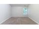 A simple bedroom with neutral walls, carpeted floor and a window at 541 Shadow Valley Ct, Lithonia, GA 30058