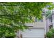 Charming home featuring tan siding, a white garage door, and well-maintained landscaping at 541 Shadow Valley Ct, Lithonia, GA 30058