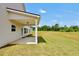 View of the rear of the house with a covered porch, green grass, and meadow at 715 Colvin Dr, Locust Grove, GA 30248