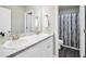 Well-lit bathroom with a double sink vanity featuring marble countertops and dark wood style flooring at 715 Colvin Dr, Locust Grove, GA 30248