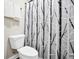 Cozy bathroom featuring a toilet and shower with a modern black and white decorative shower curtain at 715 Colvin Dr, Locust Grove, GA 30248