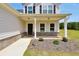 Charming front entry featuring a black front door, tasteful landscaping, and a covered porch at 715 Colvin Dr, Locust Grove, GA 30248